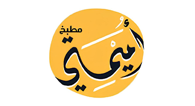 This logo is for "Umaymati Kitchen" (مطبخ أميمتي), with the name written in Arabic calligraphy inside a yellow circular background. The artistic design incorporates cooking-related elements, reflecting a brand related to food, catering, or a restaurant.